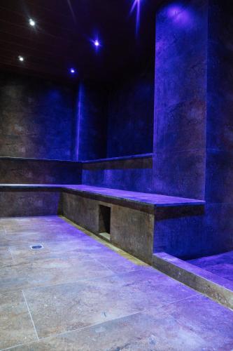 un escenario con un banco en una habitación con luces azules en habitación con baño privado se comparte cocina cerca al aeropuerto, en Santa Cruz de la Sierra