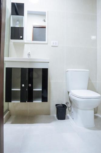a white bathroom with a toilet and a sink at habitación con baño privado se comparte cocina cerca al aeropuerto in Santa Cruz de la Sierra