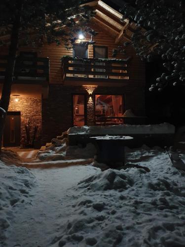 une cour couverte de neige devant une maison dans l'établissement Snježna vikendica, à Risovac