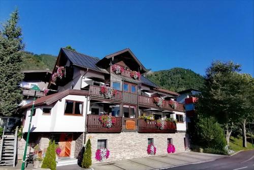 a building with flowers on the balconies of it at Haus Ditzer - Villa Theresia in Zell am See