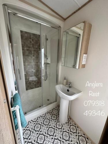 a bathroom with a shower and a sink at Anglers Rest, with Hot Tub and Private Fishing Peg in Tattershall