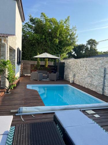 - une piscine sur une terrasse en bois avec un parasol dans l'établissement Villa Ponticchio, à Santa-Lucia-di-Moriani