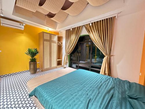 a bedroom with a blue bed and a window at A4 Home - Ha Long city Central in Ha Long