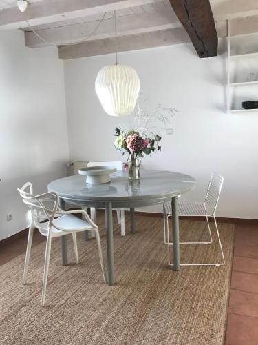 a dining room table with chairs and a vase of flowers at eichHAUS Eifel in Rheinbach