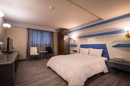 a bedroom with a bed and a blue and white striped wall at Golden Phoenix Hotel in Kaohsiung