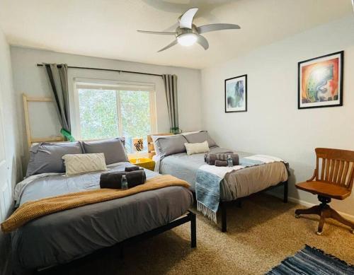 a bedroom with two beds and a ceiling fan at Artists Condo GAME ROOM Patio near UC Med Center in Sacramento