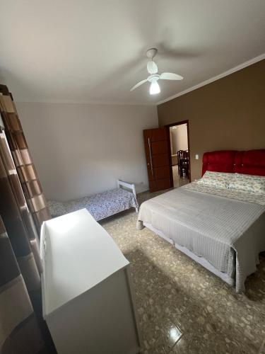 a bedroom with two beds and a table in it at Chácara Familiar Boituva in Boituva