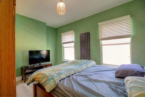a bedroom with a bed and a flat screen tv at Davis Street in London