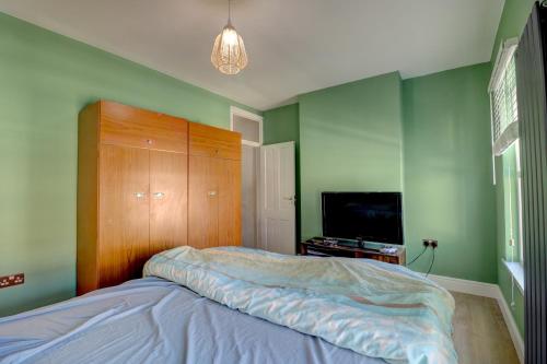 a bedroom with a bed with a wooden headboard and a television at Davis Street in London