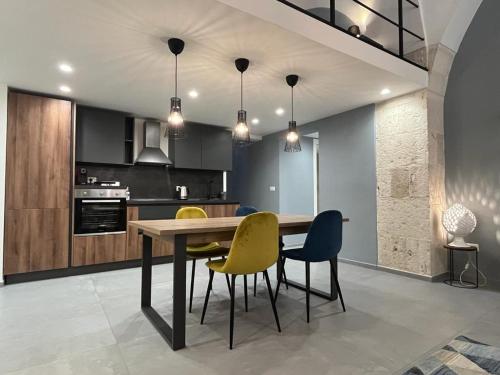 a kitchen with a wooden table and yellow chairs at San Giacomo Loft Apartment in Barletta