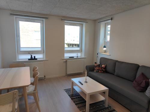 sala de estar con sofá y mesa en Aalborg City Rooms ApS, en Aalborg
