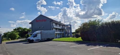 a white truck parked in a parking lot in front of a building at Fasthotel Roissy - Saint-Witz in Saint-Witz
