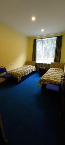 a room with two beds and a large window at ApartHotel in Alaverdi in Alaverdi