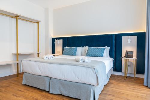a bedroom with a large bed with towels on it at Hotel Boutique La Brisa del Mar in Estepona