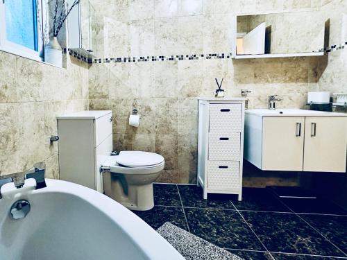 La salle de bains est pourvue d'une baignoire, de toilettes et d'un lavabo. dans l'établissement Zoya’s Place in Harrow, à Pinner