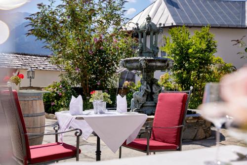 a table with two chairs and a fountain at Hotel Schloss Mittersill in Mittersill