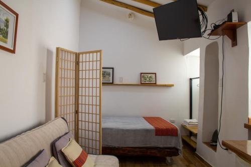 Habitación con cama, sofá y TV. en Santo Domingo, en Ayacucho