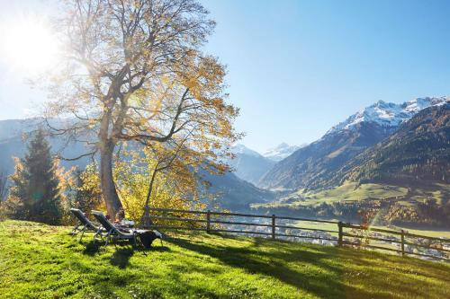 a person sitting on a bench next to a fence at Hotel Schloss Mittersill in Mittersill