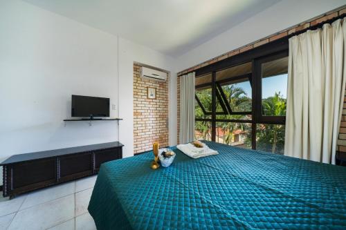 a bedroom with a bed and a large window at Pousada Albacora in Bombinhas