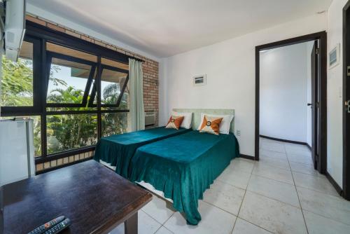 a bedroom with a bed and a large window at Pousada Albacora in Bombinhas