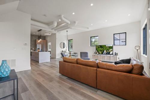 a living room with a brown couch and a kitchen at Chic Retreats in Columbus in Columbus