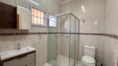 a bathroom with a shower and a toilet and a sink at Chácara Familiar Boituva in Boituva