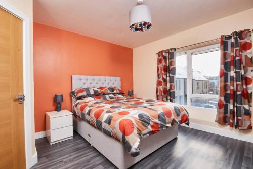 1 dormitorio con paredes de color naranja, 1 cama y ventana en Exquisite City Centre house - Parking & Garden, en Sheffield