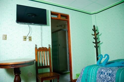 um quarto com uma cama e uma televisão na parede em HOSTAL SALARCITO em Uyuni