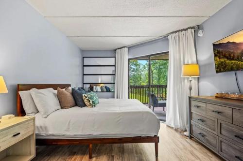 a bedroom with a bed and a large window at VIEWS and FIREPLACE and Minutes to Gburg and Ober in Gatlinburg