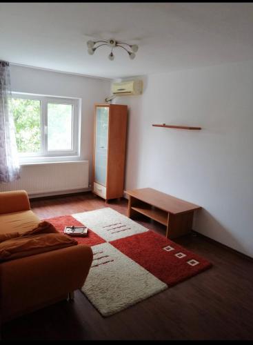- un salon avec un canapé et un tapis dans l'établissement Apartament Ploiesti, à Ploieşti