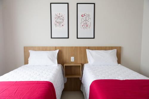 two beds sitting next to each other in a room at Daho Hotel in Natal