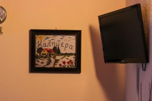 a flat screen tv next to a picture on a wall at Mylos in Arkochórion
