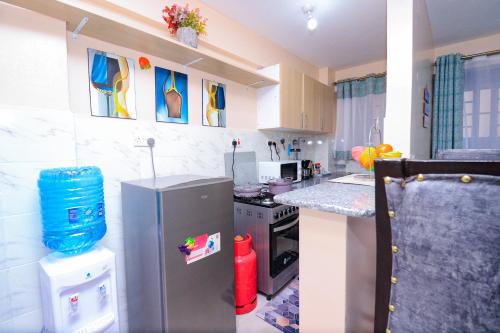 a small kitchen with a refrigerator and a stove at One bedroom furnished apartment ,south B in Nairobi