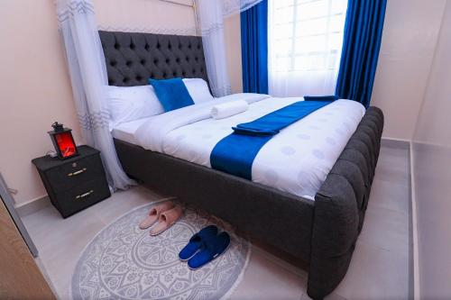 a bedroom with a large bed with blue sheets and a window at One bedroom furnished apartment ,south B in Nairobi
