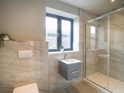 a bathroom with a shower and a sink and a toilet at Farley Meadow View in Matlock