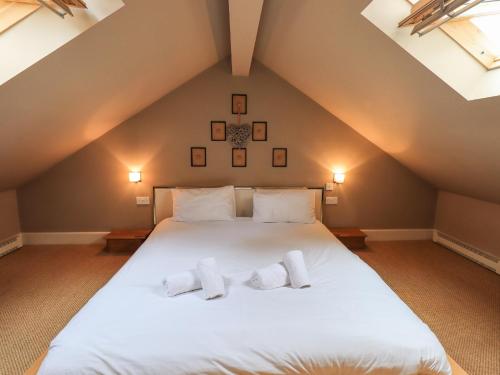 a bedroom with a white bed with two towels on it at Dove Tail Barn in Underbarrow