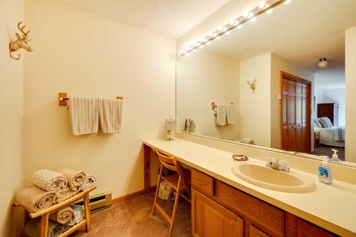 a bathroom with a sink and a large mirror at Riverfront Lincoln Condo with Pool Mins to Loon Mtn in Lincoln