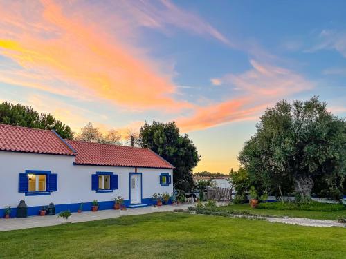 a white house with a red roof and a yard at Quinta do Cutato - Soba Guest House in Santo Estêvão