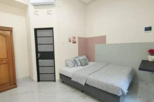 a bedroom with a bed in a white room at Dulcon278 in Sukarami