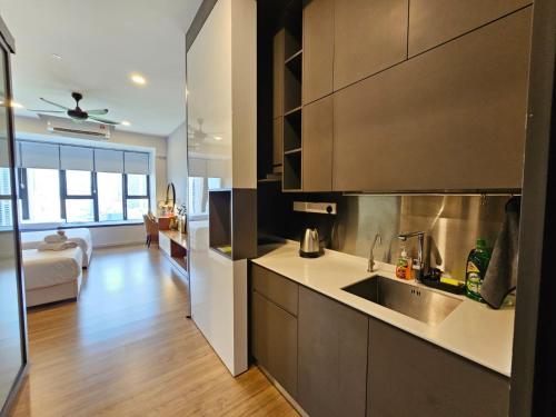 a kitchen with a sink and a living room at Luxurious Ceylonz Suite near Bukit Bintang 4pax in Kuala Lumpur