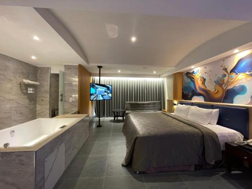a bedroom with a bed and a tub and a television at King & Princess Motel - Rende in Rende