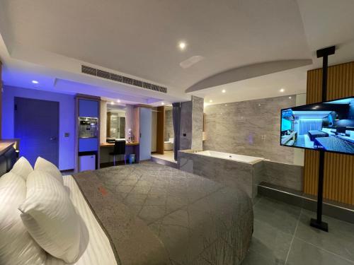 a bedroom with a large bed and a flat screen tv at King & Princess Motel - Rende in Rende