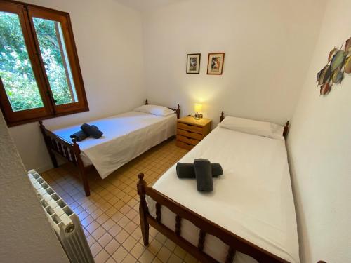 two beds in a small room with a window at Spectacular Mediterranean view! in Palafrugell