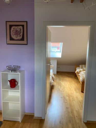 a room with purple walls and a hallway with a table at Ferienwohnung Jeßberger in Bad Königshofen im Grabfeld