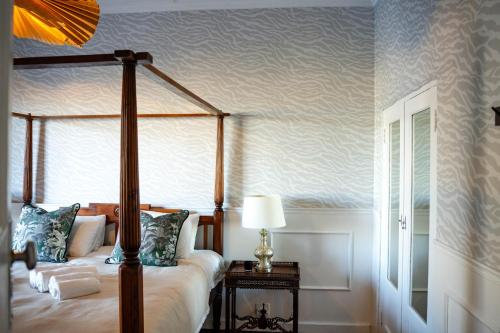 1 dormitorio con cama con dosel y lámpara en una mesa en The Spirit of the Cape, en Ciudad del Cabo