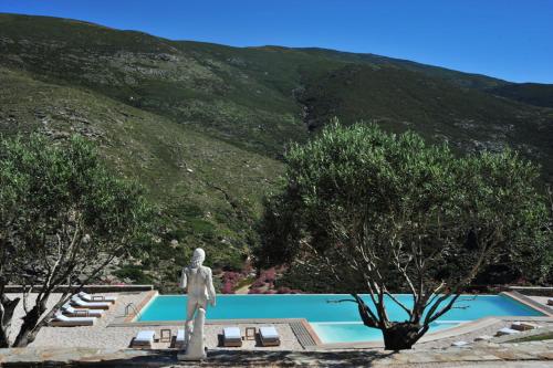 a statue standing in front of a swimming pool at Aegea Blue Cycladic Resort in Zorgos 