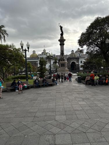 un grupo de personas sentadas alrededor de una estatua en un parque en Apartamento entero con piscina, en Portoviejo