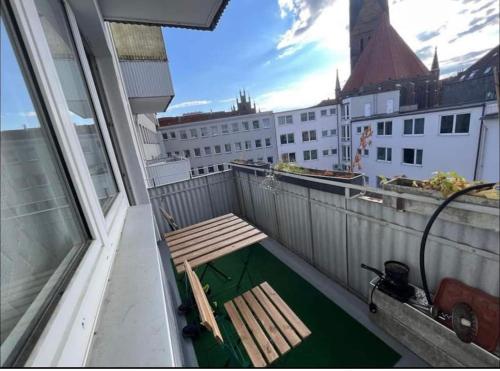 a balcony with a wooden bench on top of a building at Middle of the city center, with balcony in Hannover