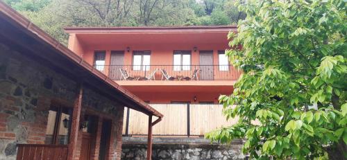 um edifício com uma varanda com cadeiras em Guest house BORJOMULA em Borjomi