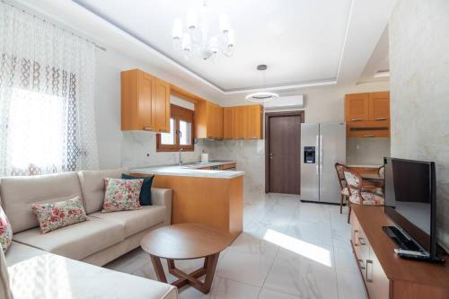 a living room with a couch and a kitchen at Διαμέρισμα με αυλή στη Μέλισσα in Xanthi